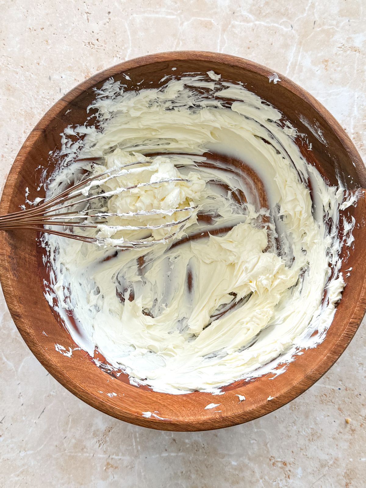 cream cheese whisked until creamy in a wooden bowl