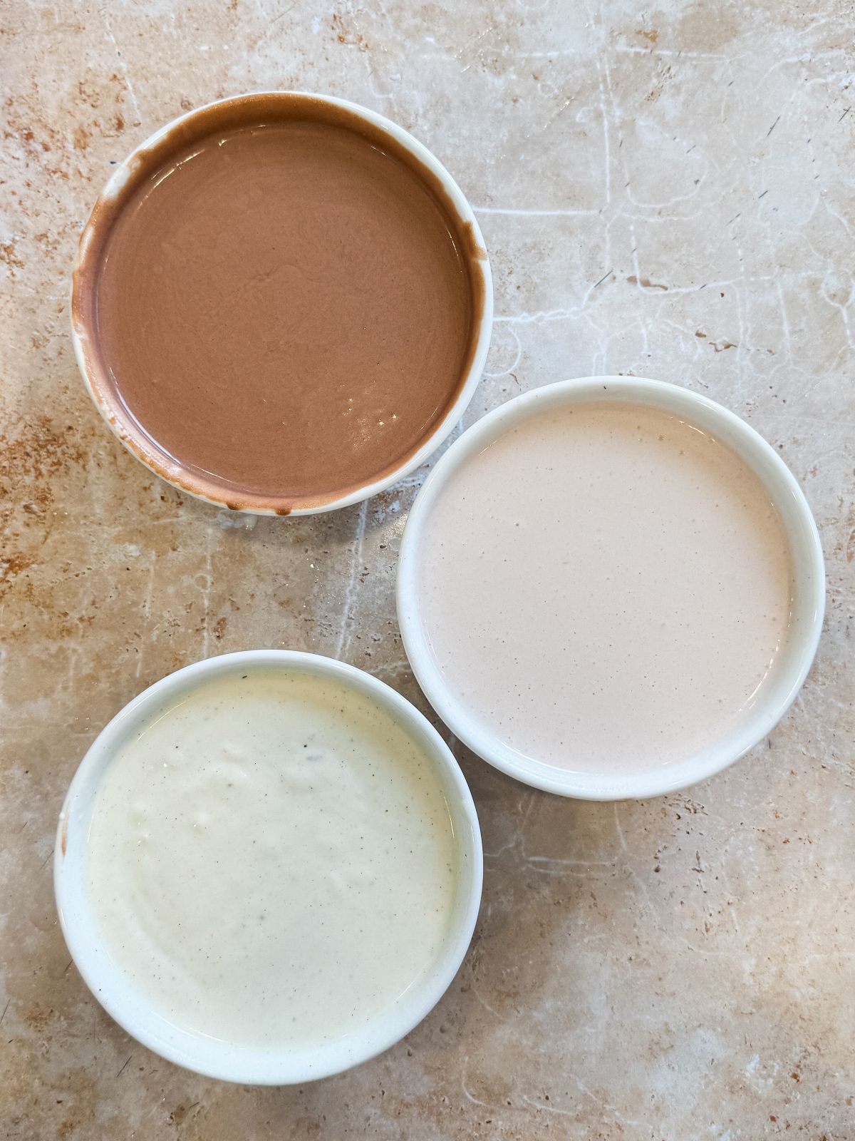 3 bowls with melted chocolate, vanilla and strawberry ice cream mixed with gelatin