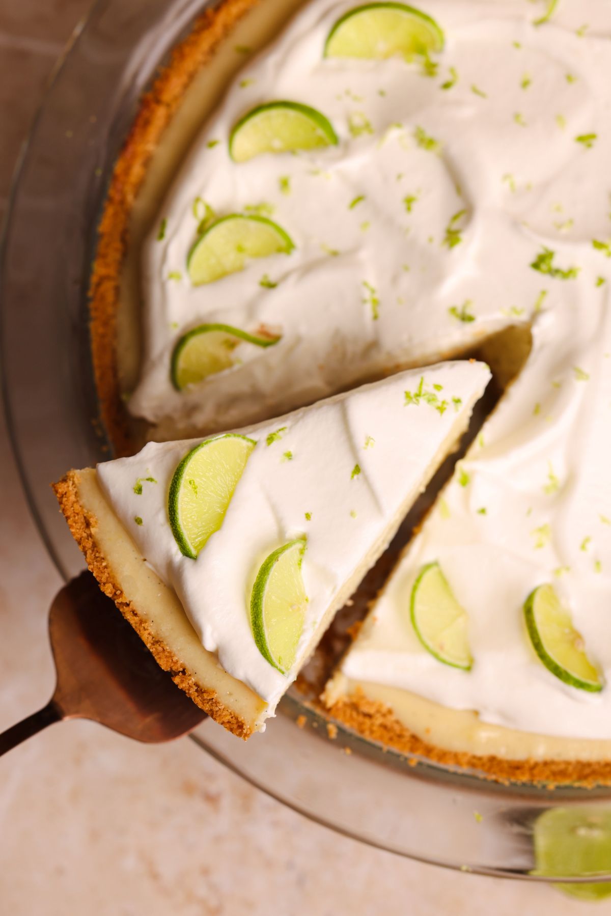 overhead picture of key lime pie with a spatula pulling out a slice