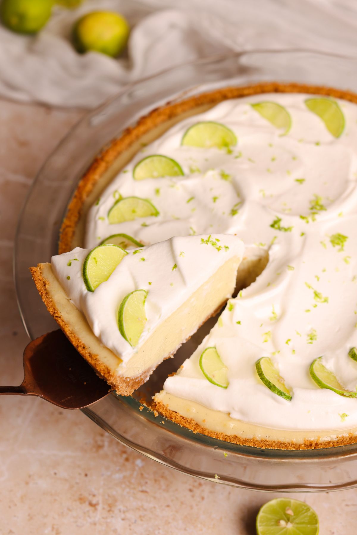 key lime pie in a pan with a spatula pulling out a slice
