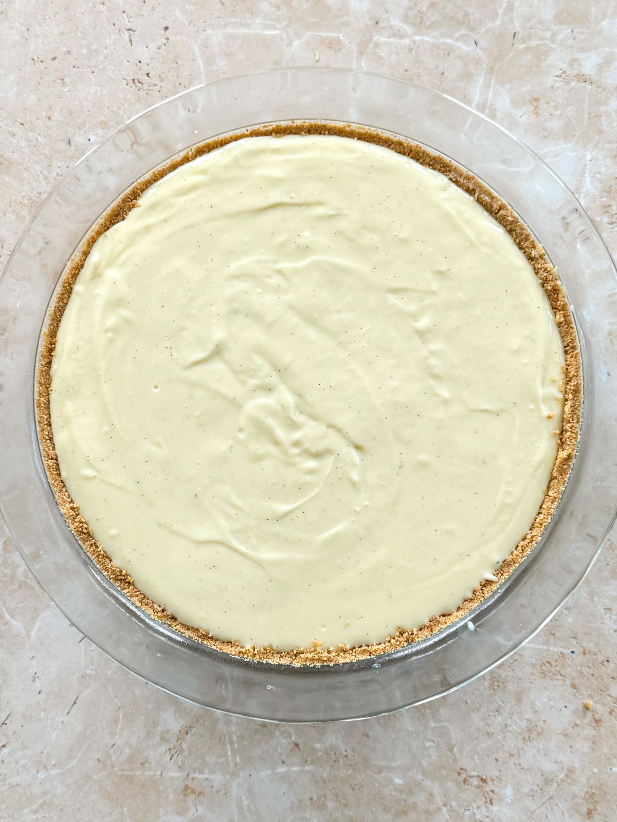 key lime pie filling added to baked crust in a pan
