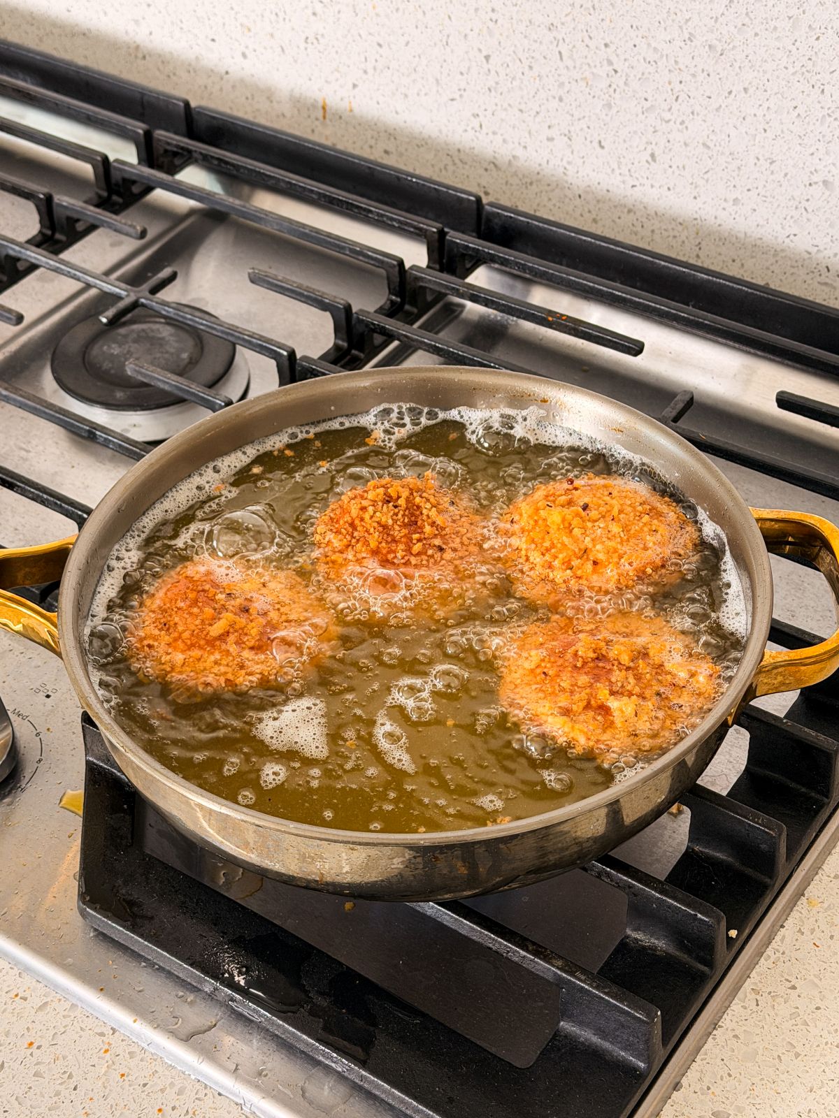 4 pot pie bread pockets being deep fried in oil on the stove
