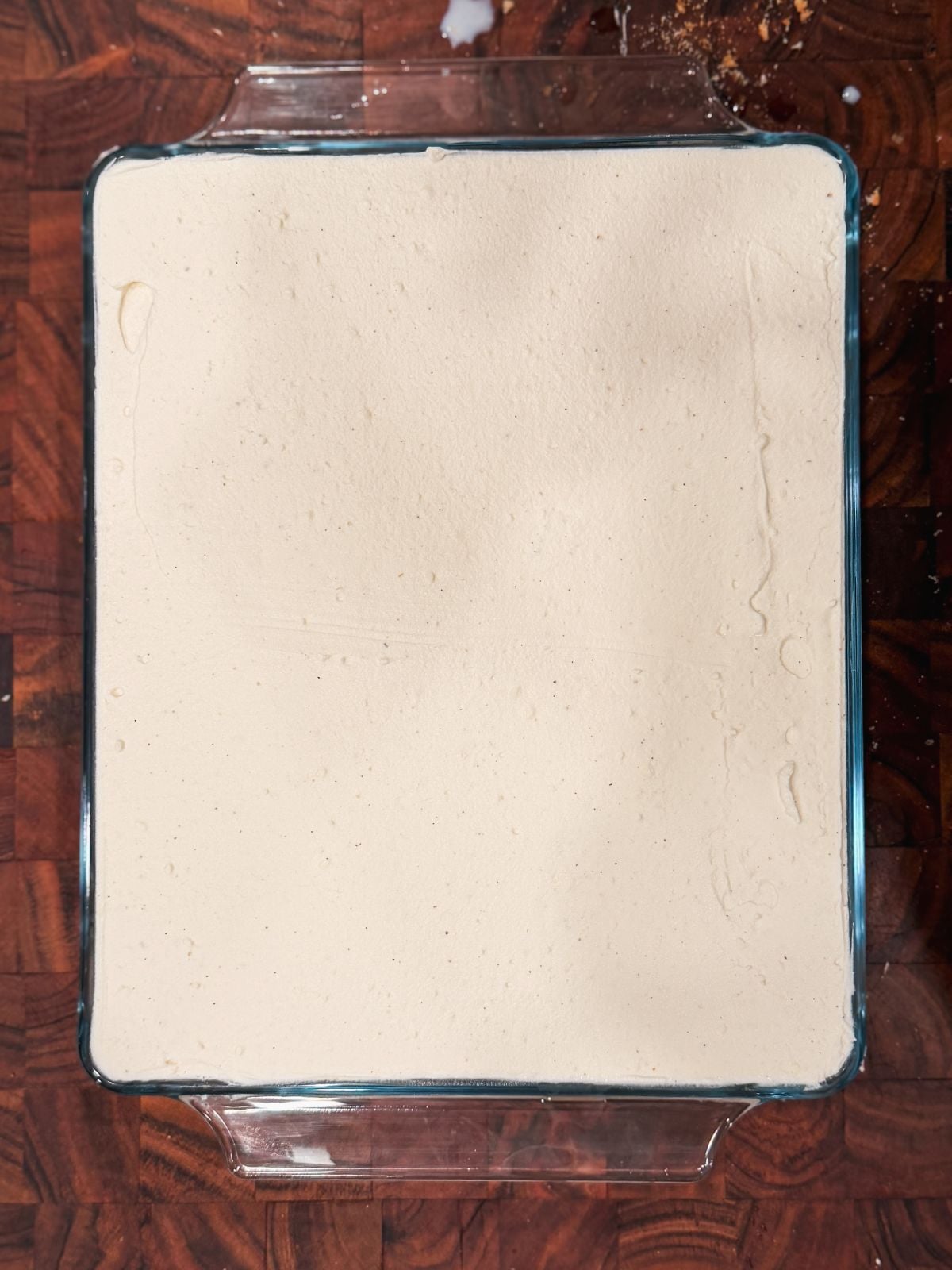 Mascarpone cream evenly spread to finish assembling rus malai tiramisu in a glass dish