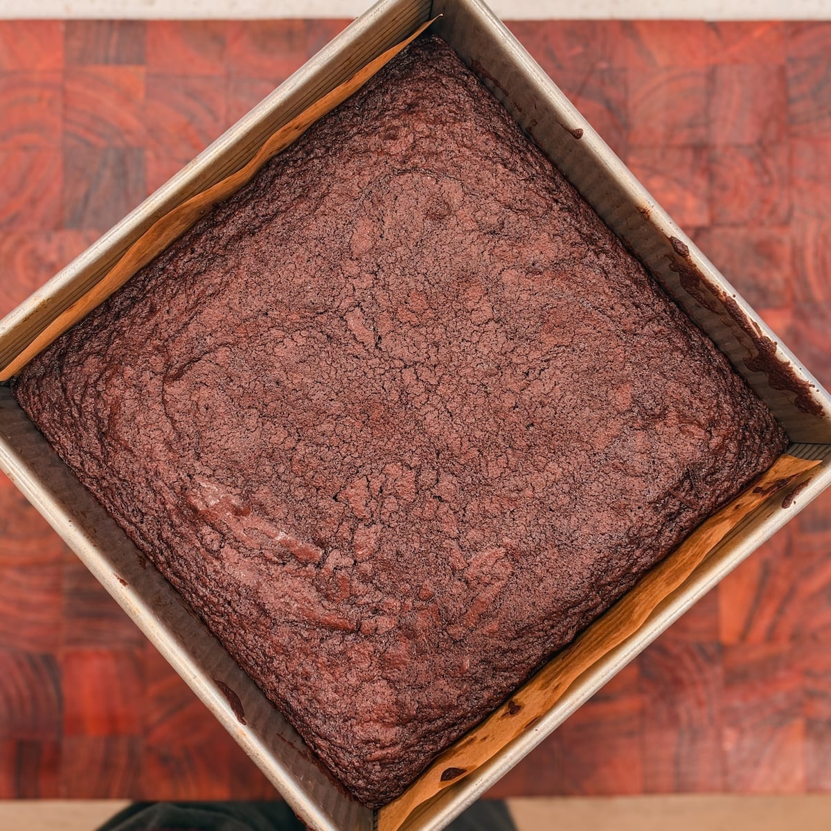 A square brownie in a metal baking pan.