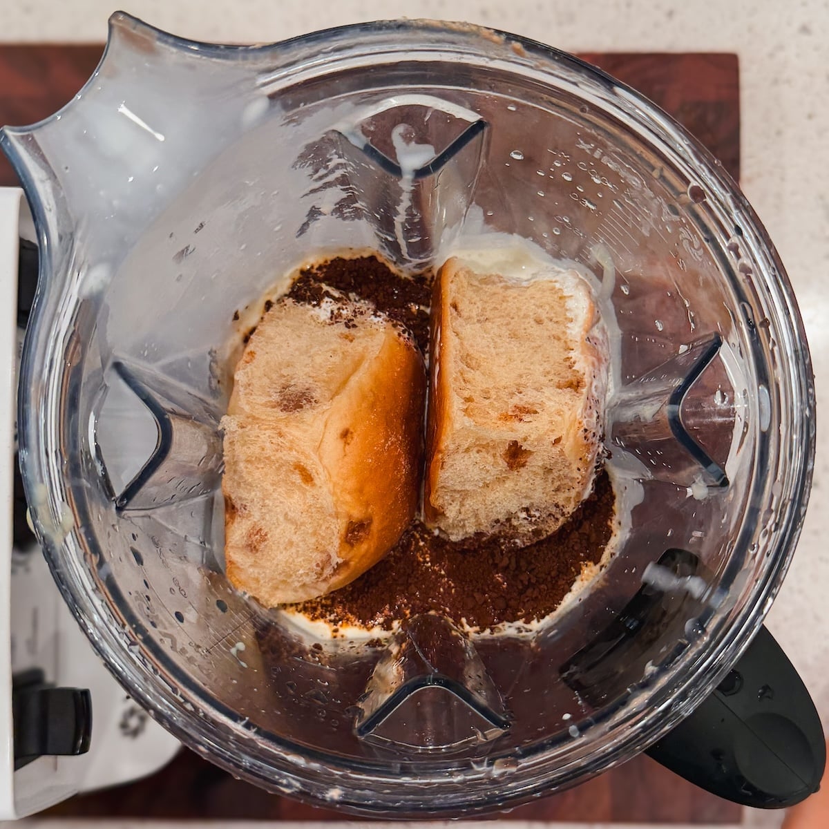 Two pieces of bread, coffee and cream in a blender pitcher.