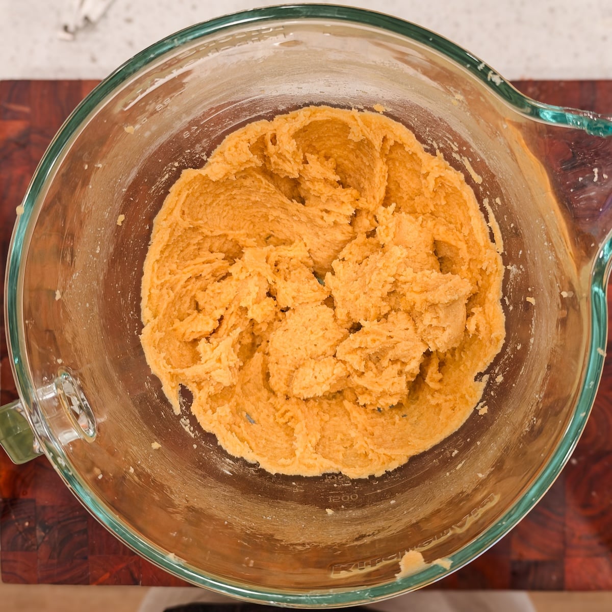 Creamed butter, sugar and egg mixture in a glass mixing bowl.